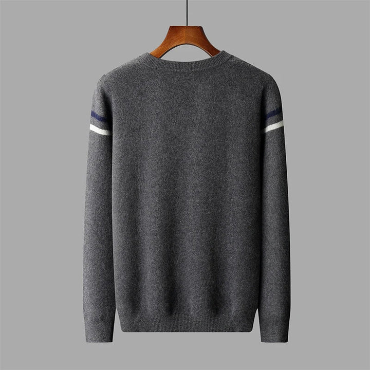 Gray sweater with white and blue stripes on sleeves on a hanger against a gray background