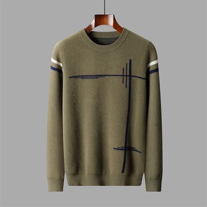 Green sweater with abstract black and white design on a gray background