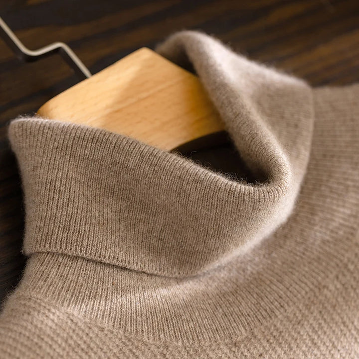 Close-up of a beige sweater on a wooden hanger against a dark background