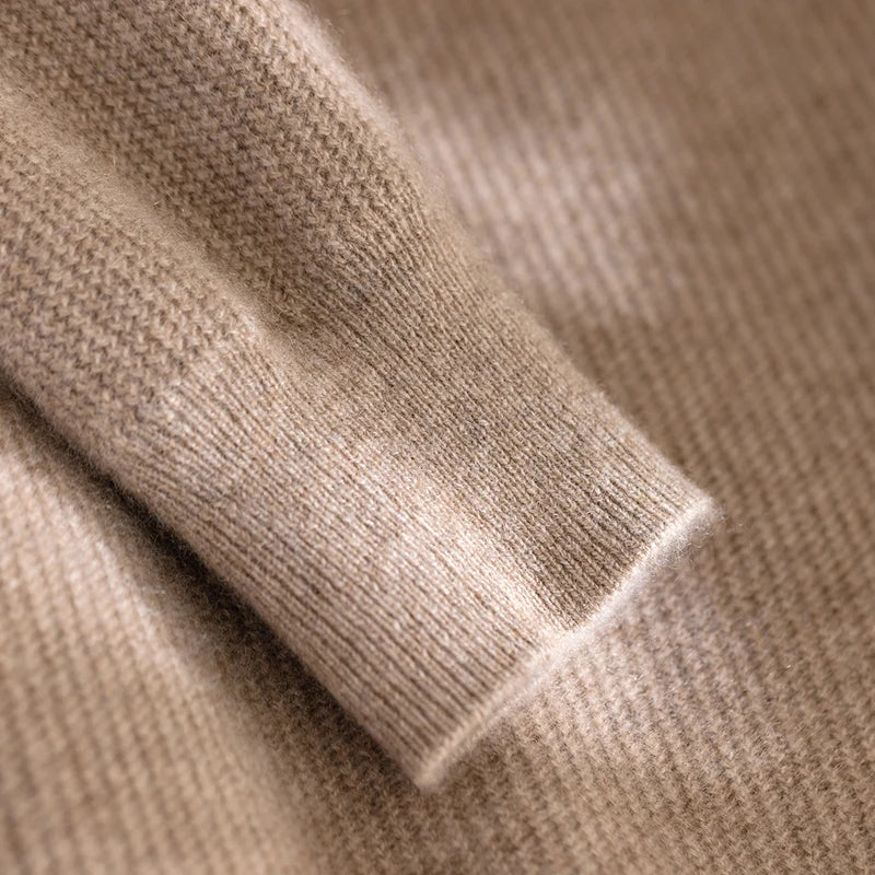 Close-up of beige knitted fabric with a focus on texture and color.
