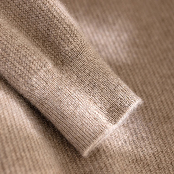 Close-up of beige knitted fabric with a focus on texture and color.