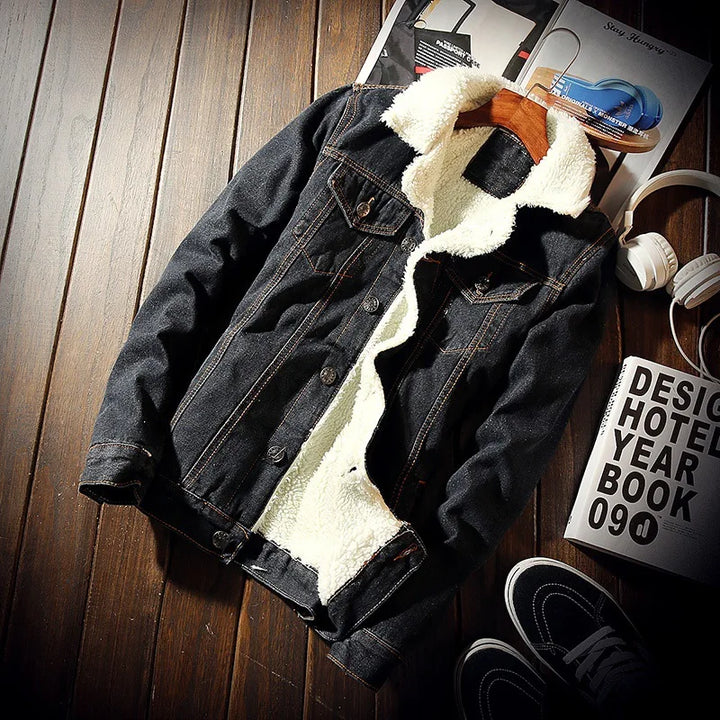 Denim jacket with white fur lining on a wooden surface with books and shoes.