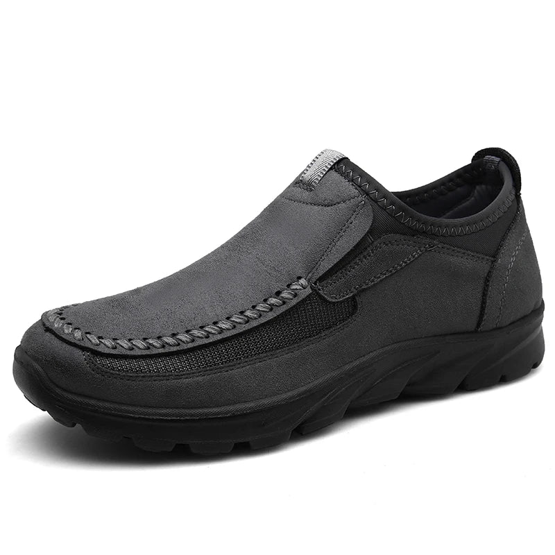 Gray slip-on shoe with black sole on a white background