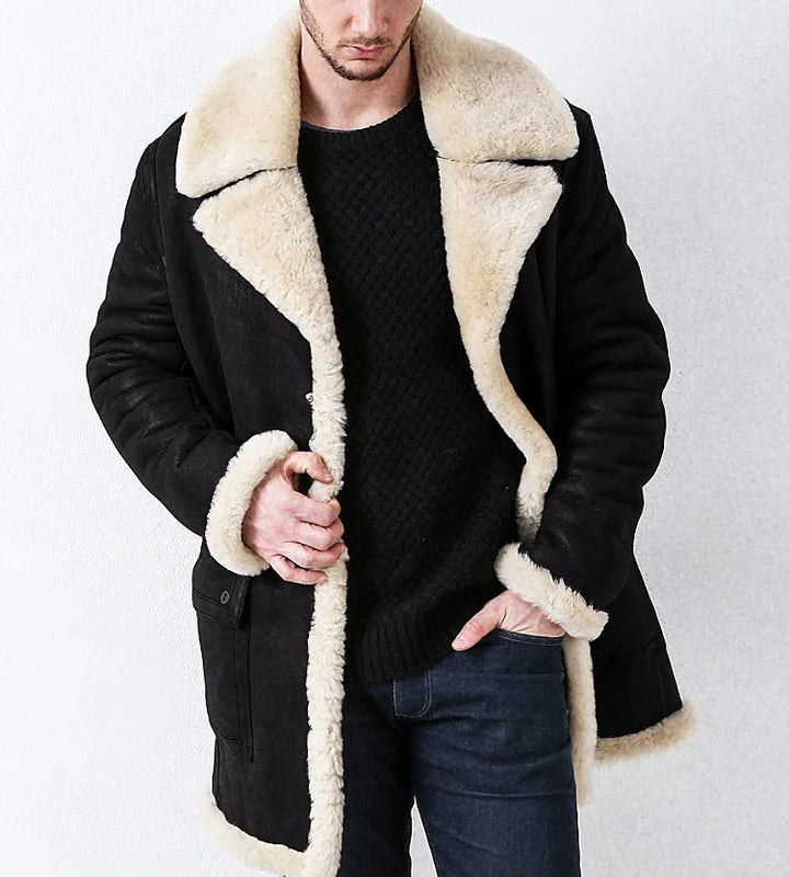 Man wearing a black coat with beige shearling collar and cuffs on a white background