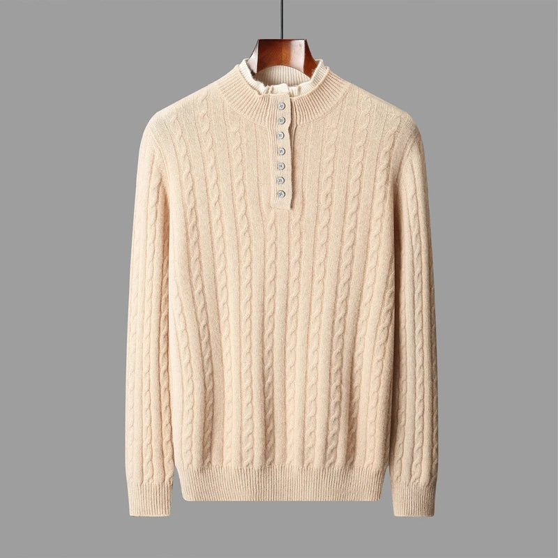 Beige cable knit sweater on a hanger against a gray background