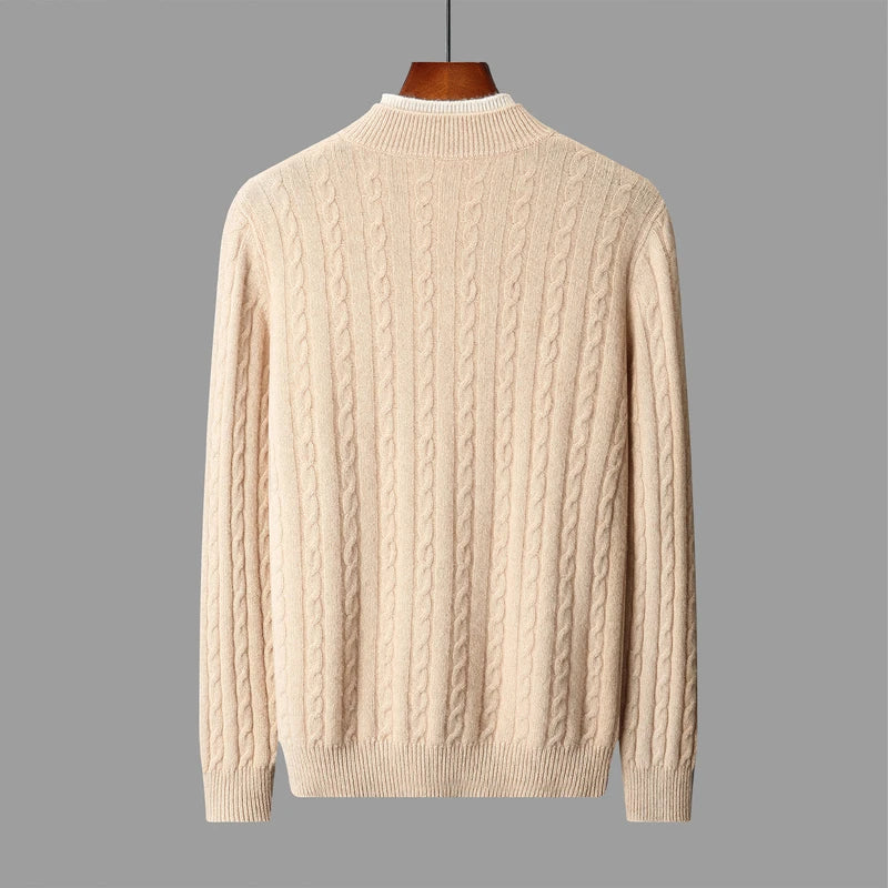 Beige cable knit sweater on a gray background