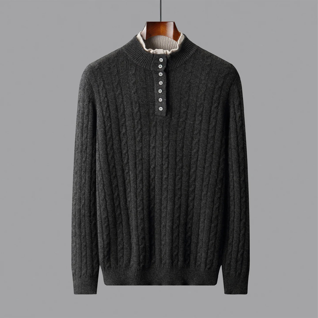 Dark gray cable knit sweater on a hanger against a gray background