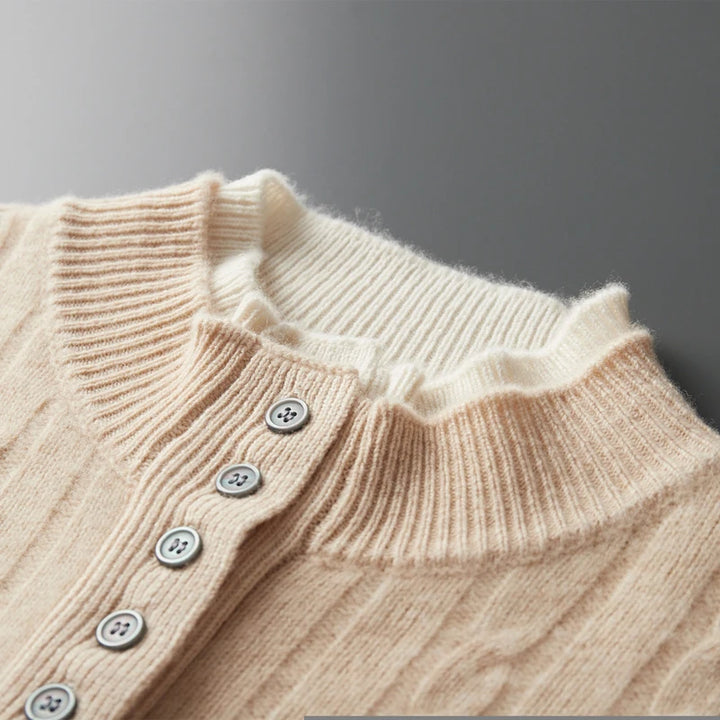 Close-up of a beige knitted sweater with buttons on a dark background