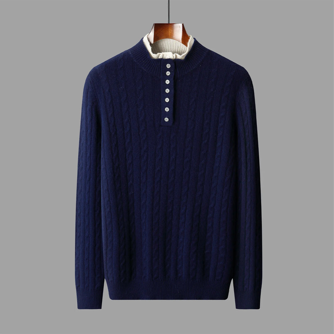 Navy blue cable knit sweater on a hanger against a gray background