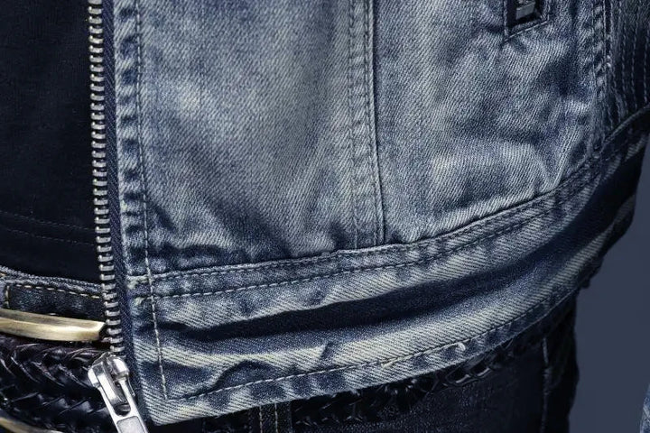 Close-up of a person wearing a dark denim jacket with a zipper.