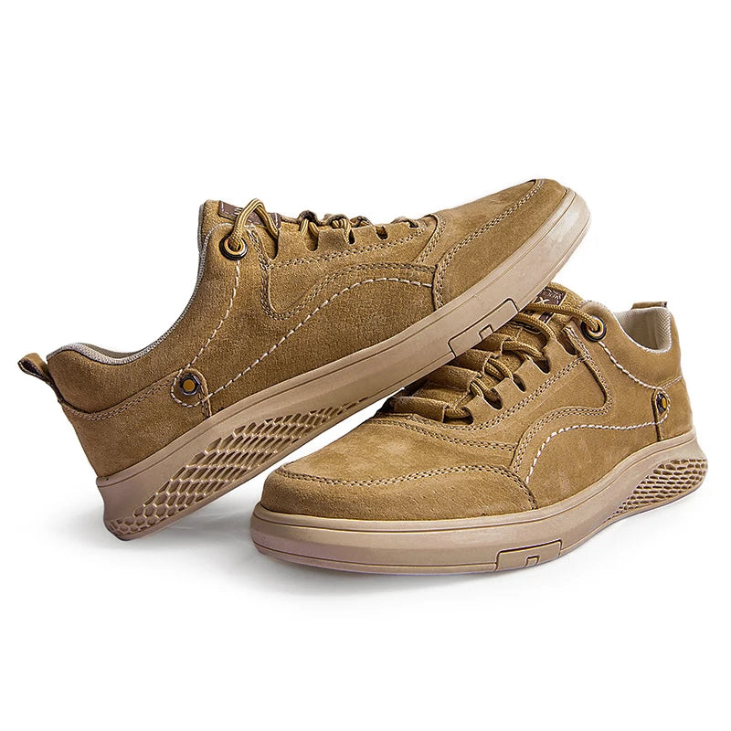 Pair of tan sneakers on a white background