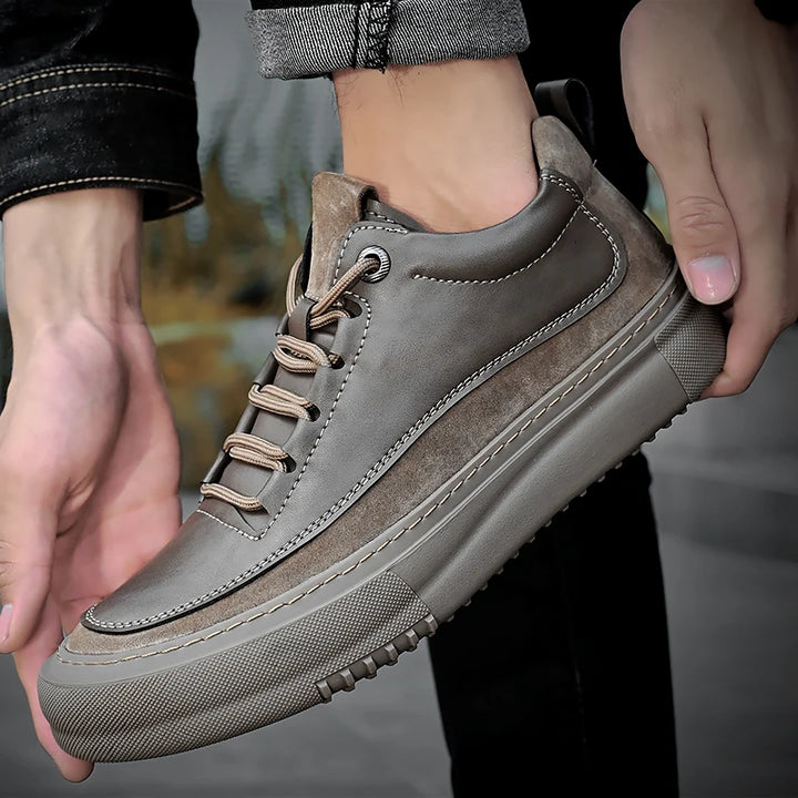 Brown leather sneaker being held with a blurred background