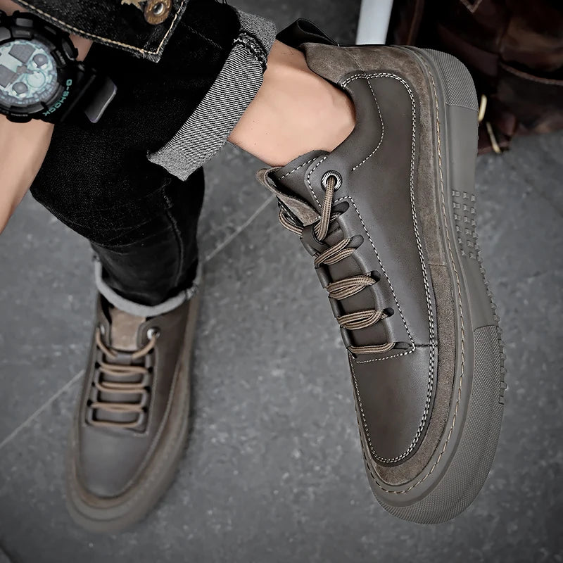 Person wearing brown leather shoes on a gray pavement
