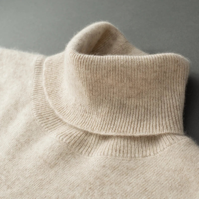 Close-up of a beige turtleneck sweater against a gray background