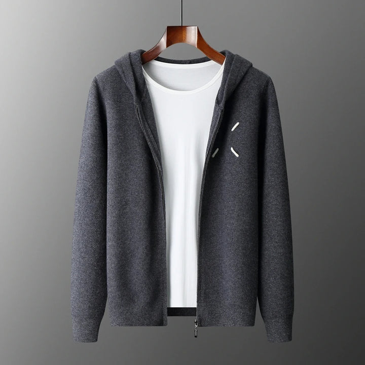Gray hoodie with a zipper on a wooden hanger against a gray background