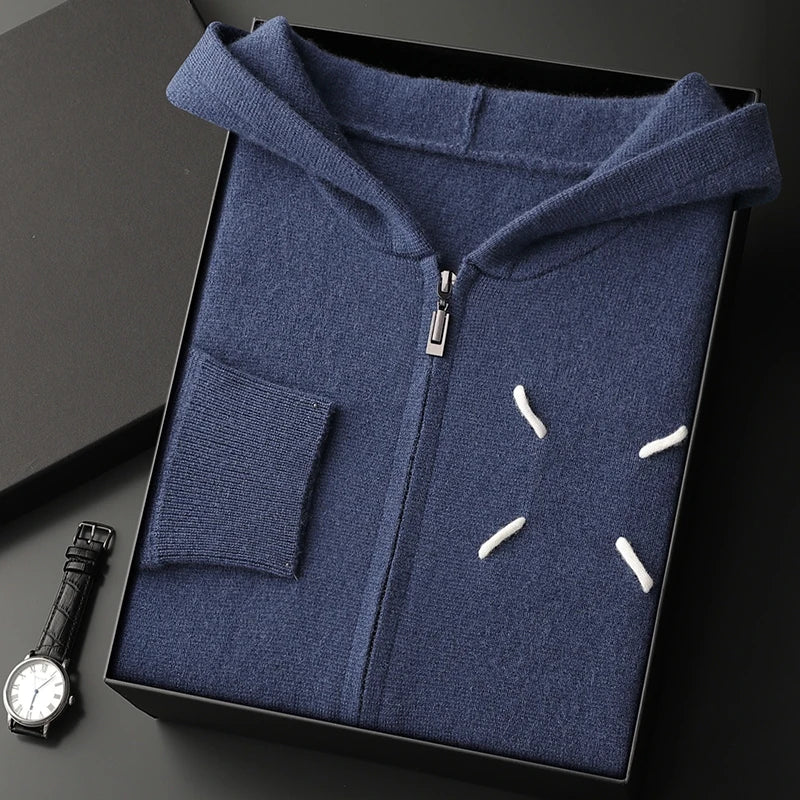Blue hoodie with white accents in a black box, next to a watch on a dark surface.