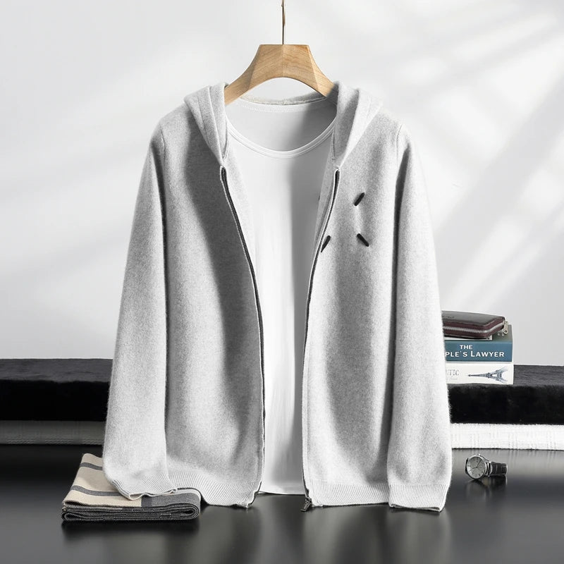 Light gray cardigan over a white t-shirt on a hanger with a minimal background