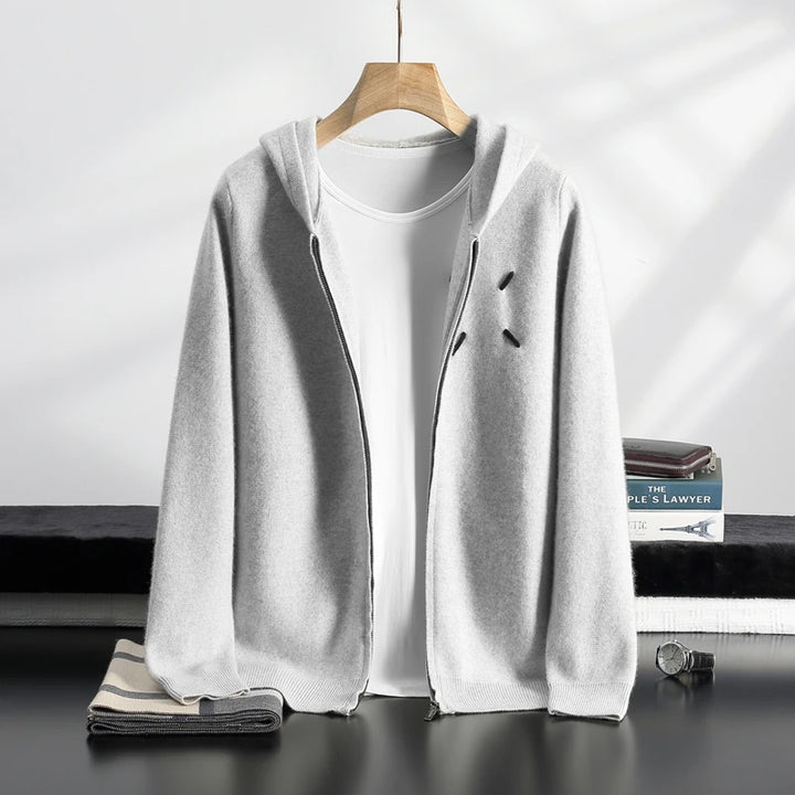 Light gray cardigan over a white t-shirt on a hanger with a minimal background