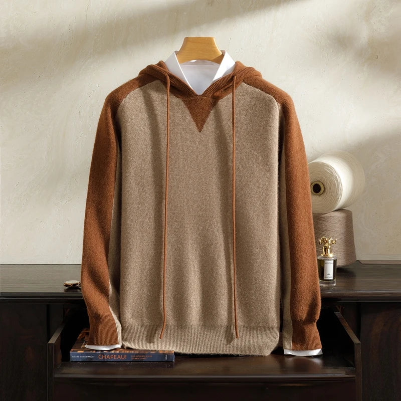 Brown and beige hoodie on a wooden hanger against a neutral background