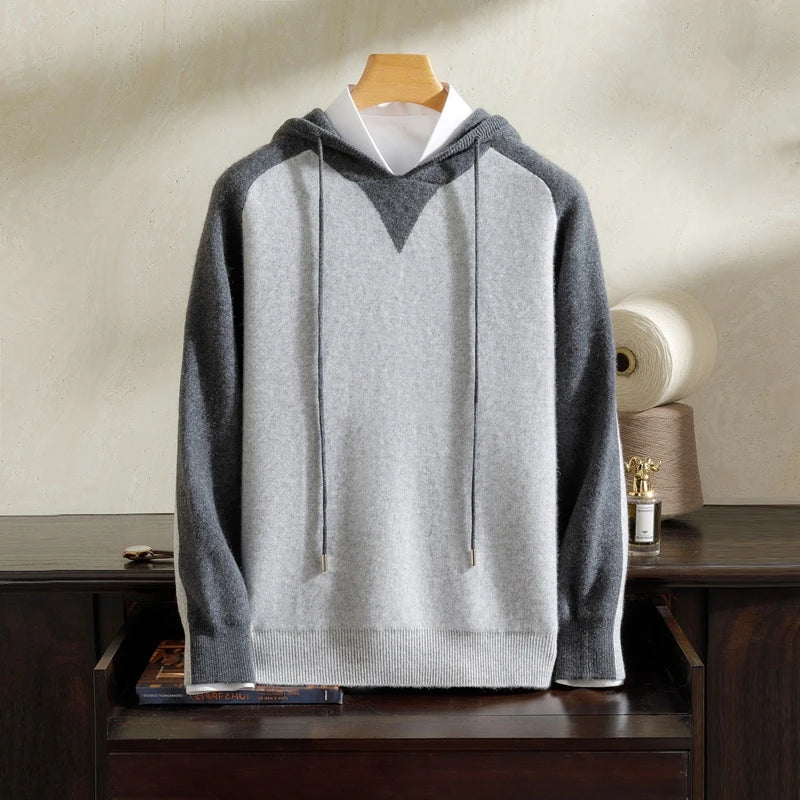 Gray hoodie on a wooden hanger against a neutral background