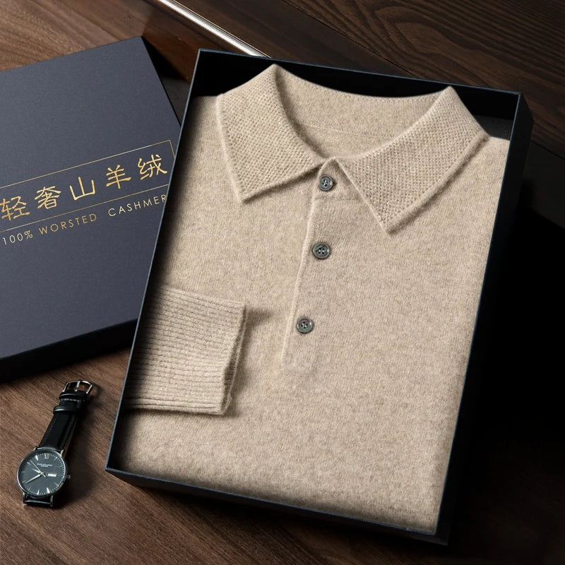 Folded beige sweater in a box with a watch on a wooden surface