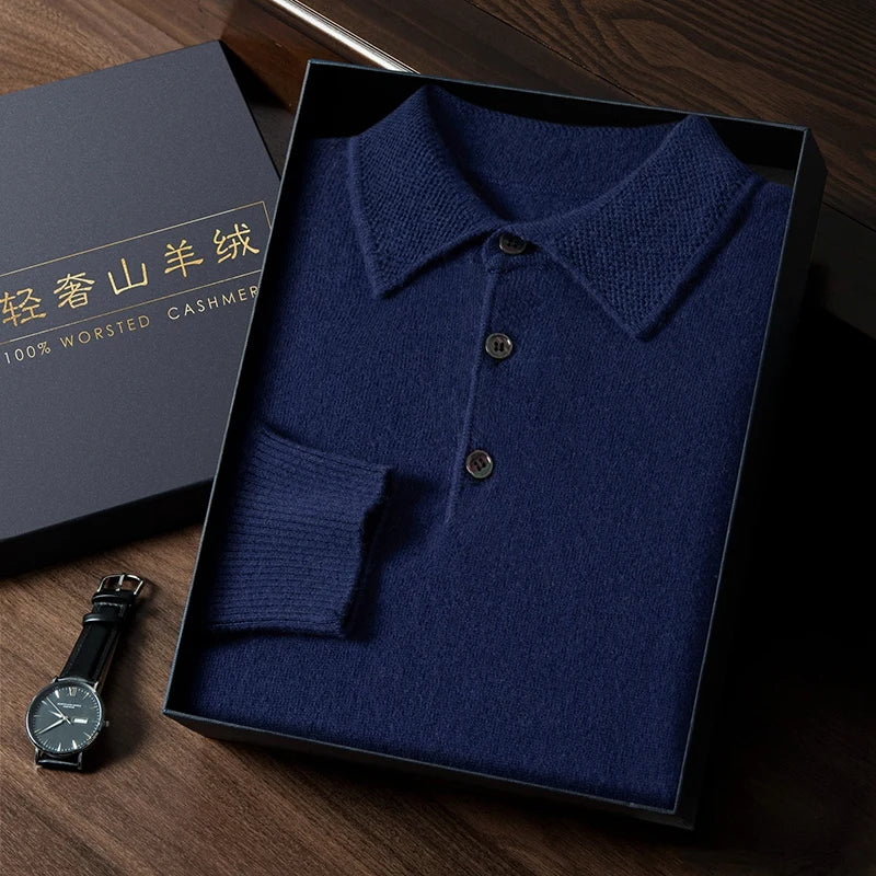 Blue knitted polo shirt in a box with a watch on a wooden surface