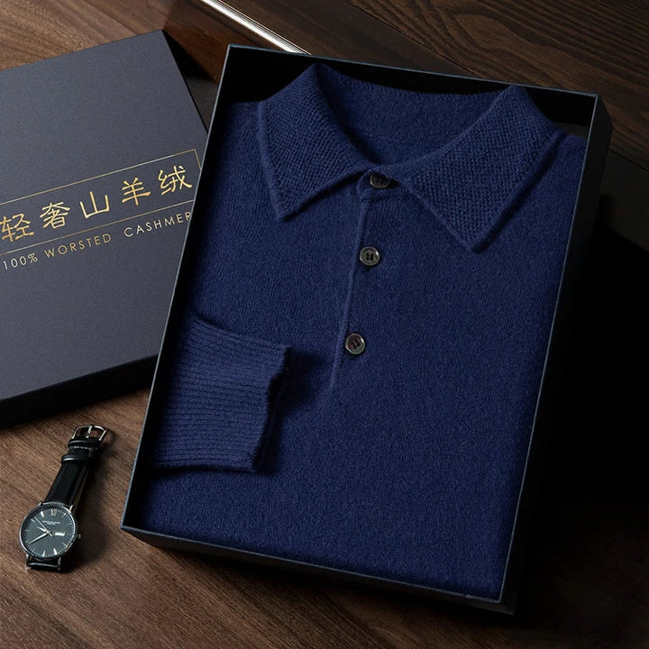 Blue knitted polo shirt in a box with a watch on a wooden surface