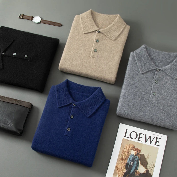 Folded polo shirts in black, beige, blue, and gray on a gray surface with a Loewe magazine.