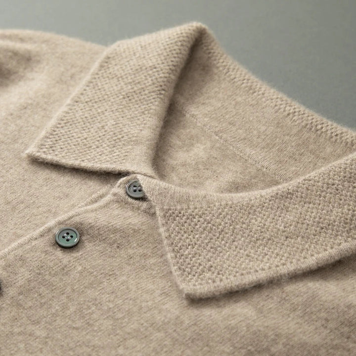 Close-up of a beige textured garment with a collar and buttons on a gray background