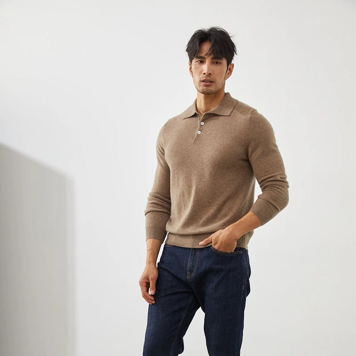 Man wearing a brown sweater and dark jeans against a white background