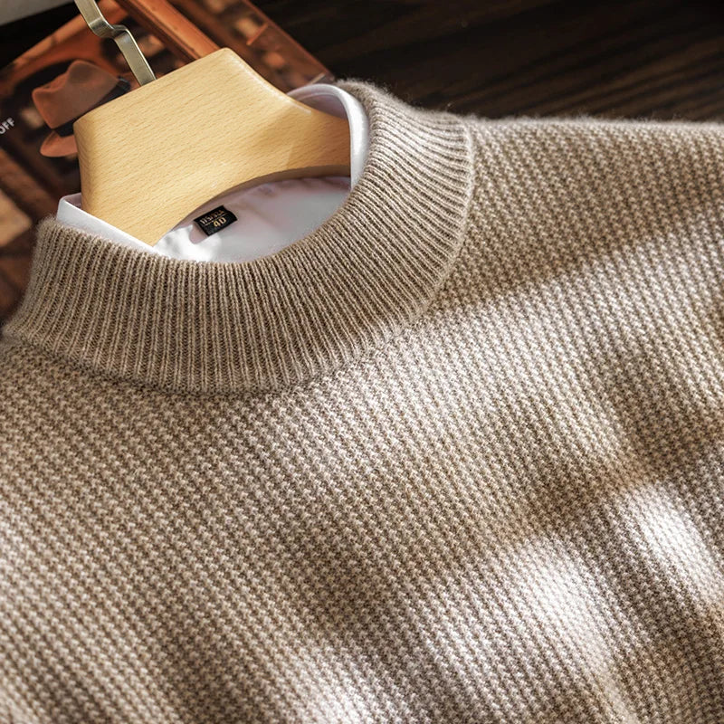 Close-up of a brown sweater on a wooden hanger with a blurred background