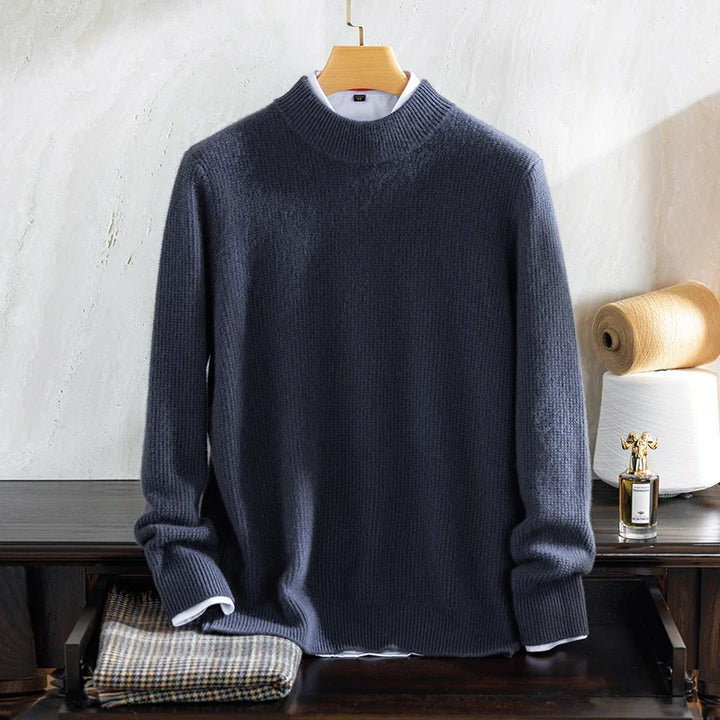 Blue sweater on a hanger against a white wall with a small table and decorative items.