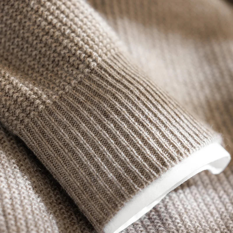 Close-up of a beige knitted sweater with a white lining.