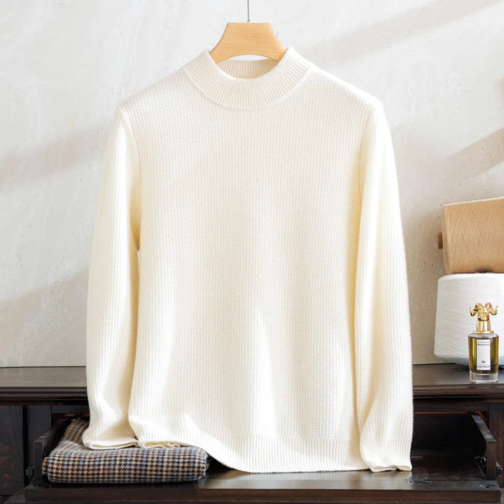White sweater on a wooden hanger against a neutral background