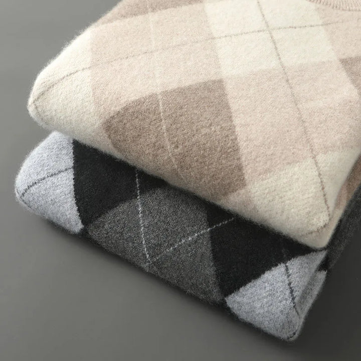 Two folded checkered sweaters in gray and beige on a gray background