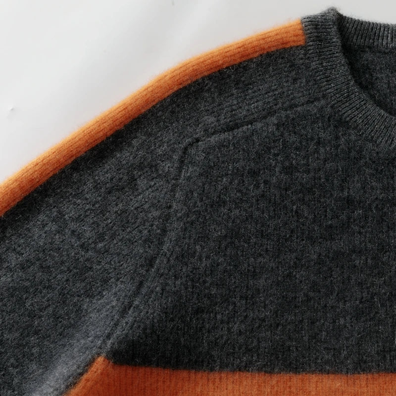 Close-up of a gray sweater with orange accents on a white background