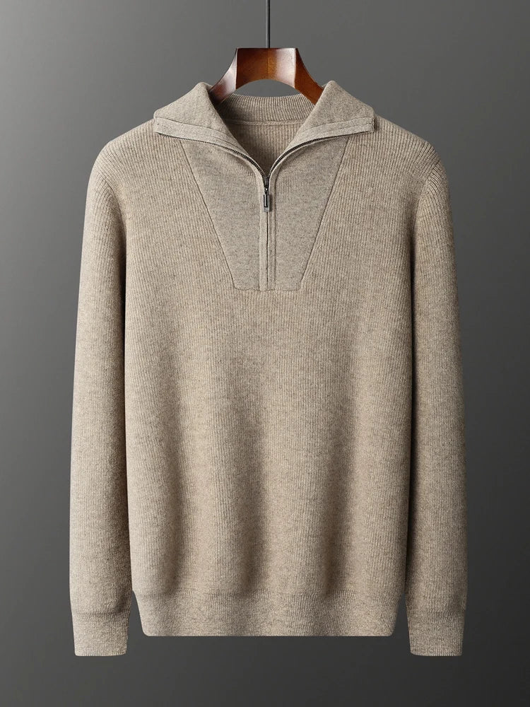 Beige sweater with a quarter zip on a hanger against a dark background