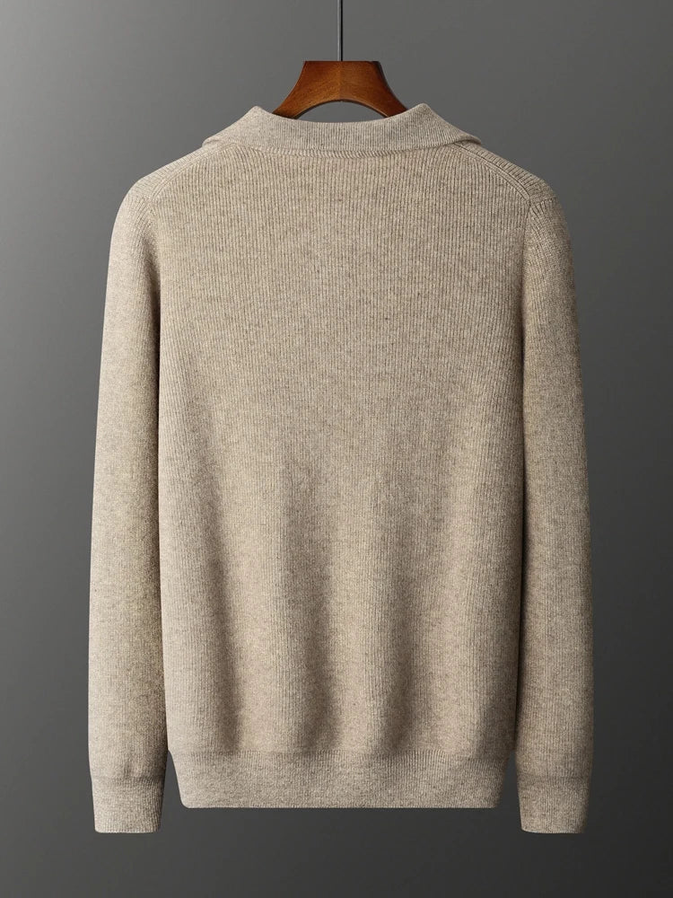 Beige sweater on a hanger against a gray background