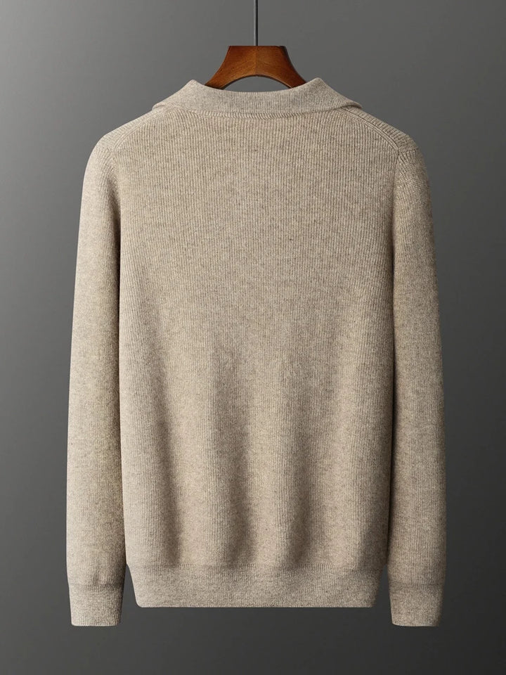 Beige sweater on a hanger against a gray background