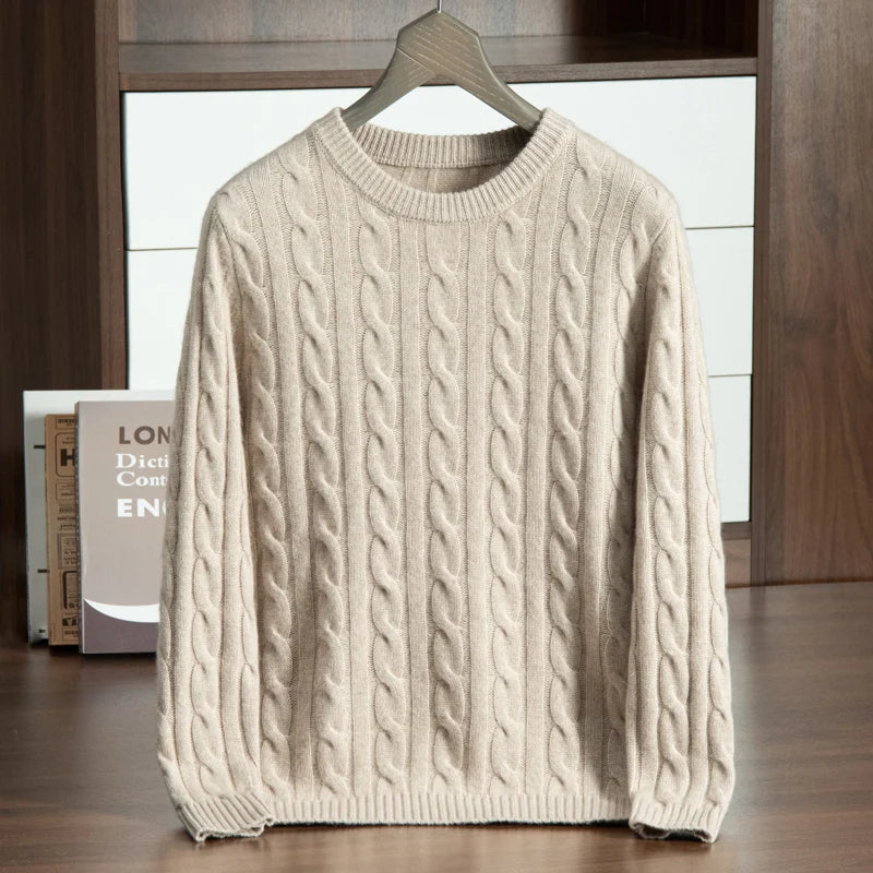 Beige cable knit sweater on a hanger against a neutral background