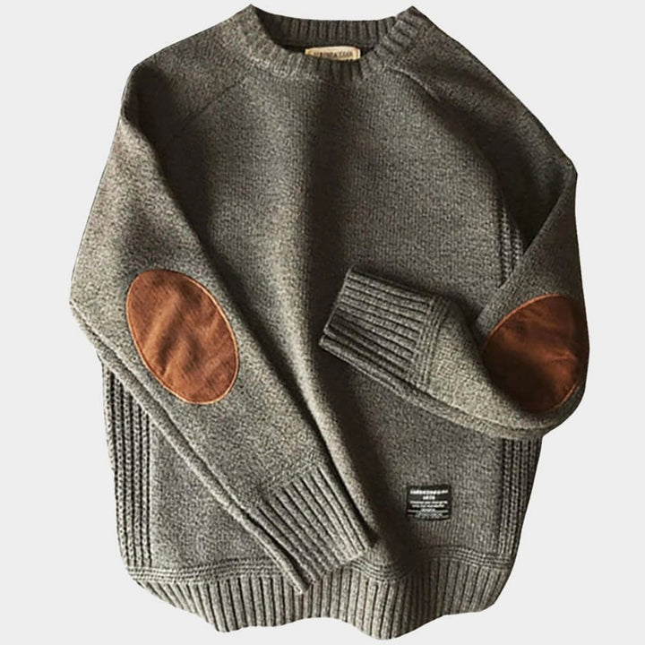 Gray sweater with brown elbow patches on a light gray background