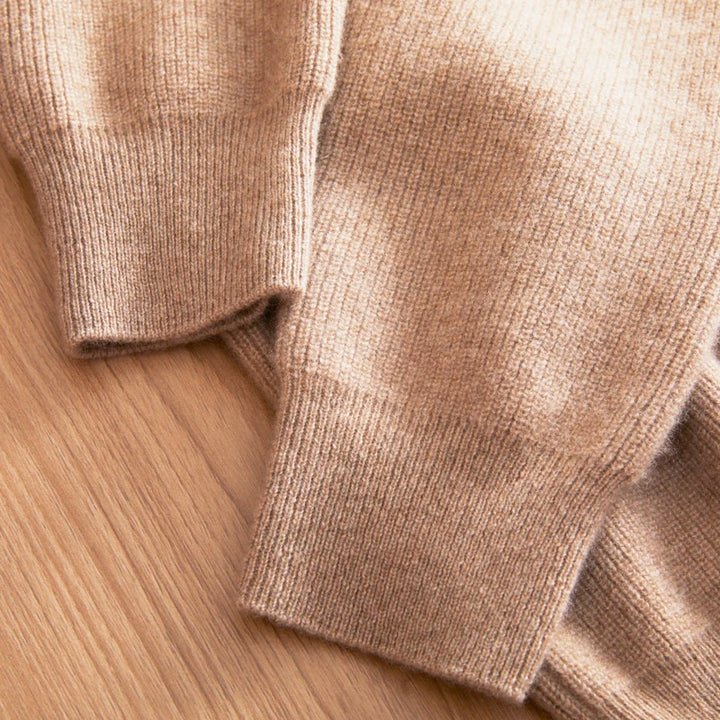 Close-up of a beige sweater on a wooden surface