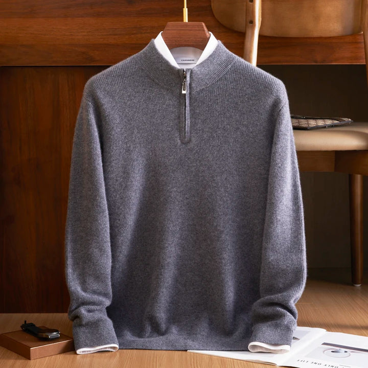 Gray sweater with a zipper on a wooden hanger against a wooden background