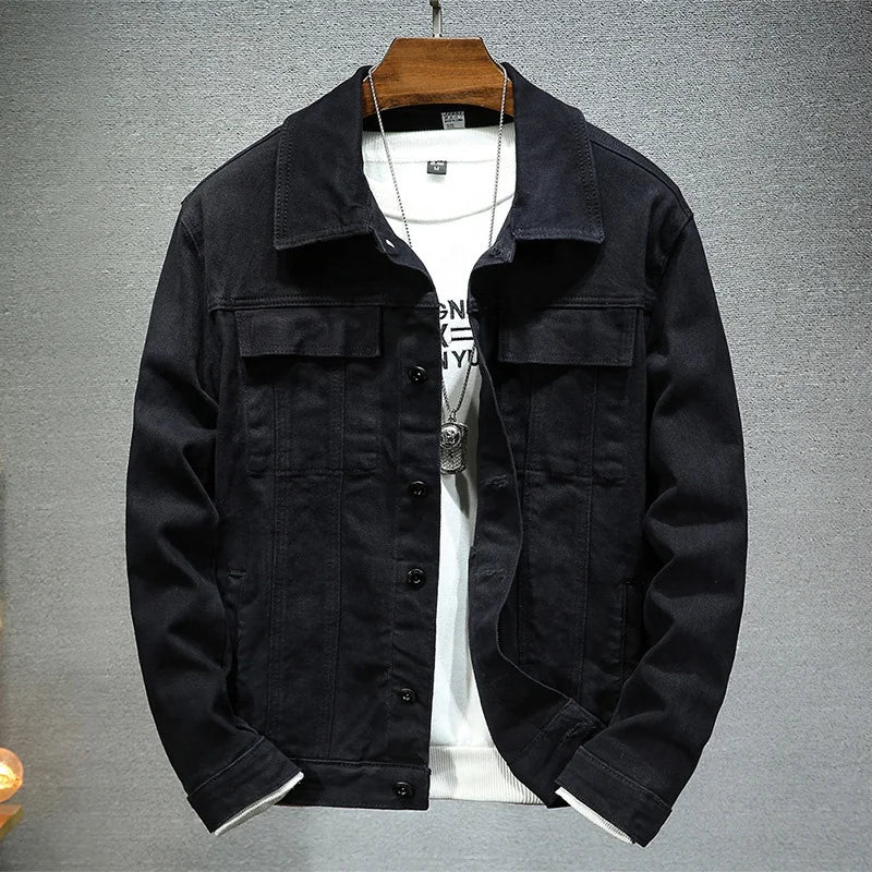Black jacket on a hanger with a white shirt underneath on a gray background
