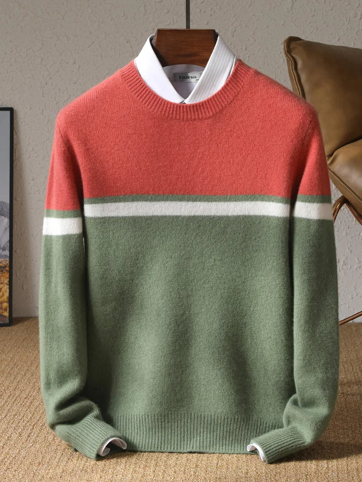 Color-blocked sweater with red, green, and white on a hanger against a neutral background