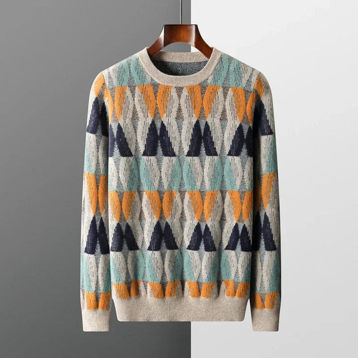 Colorful patterned sweater on a hanger against a gray background