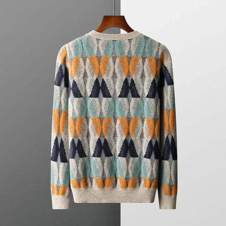 Colorful patterned sweater on a hanger against a gray background