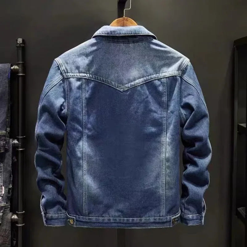 Blue denim jacket on a hanger against a dark background