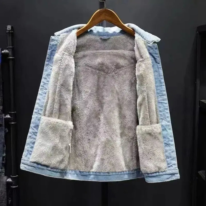 Denim jacket with fleece lining on a hanger against a dark background