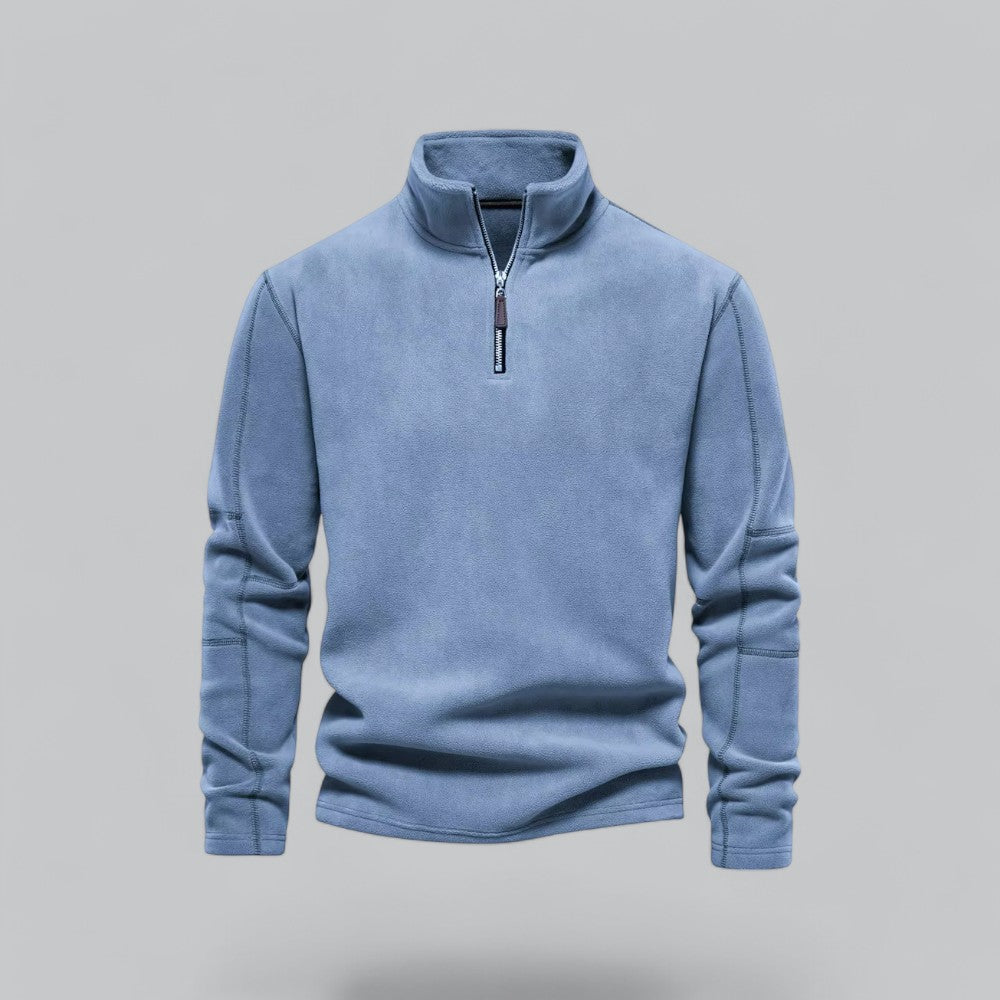 Blue fleece pullover with a zipper on a gray background